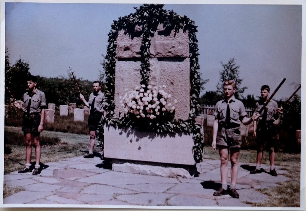 Bild 5: Am 2. Juli 1961 wurde die Gräberstätte Rurberg eingeweiht. Um das mit Pflanzen kaschierte Hochkreuz herum halten christliche Pfadfinder vom Stamm 'Karl der Große' aus Aachen Fackeln während der Zeremonie (1961).