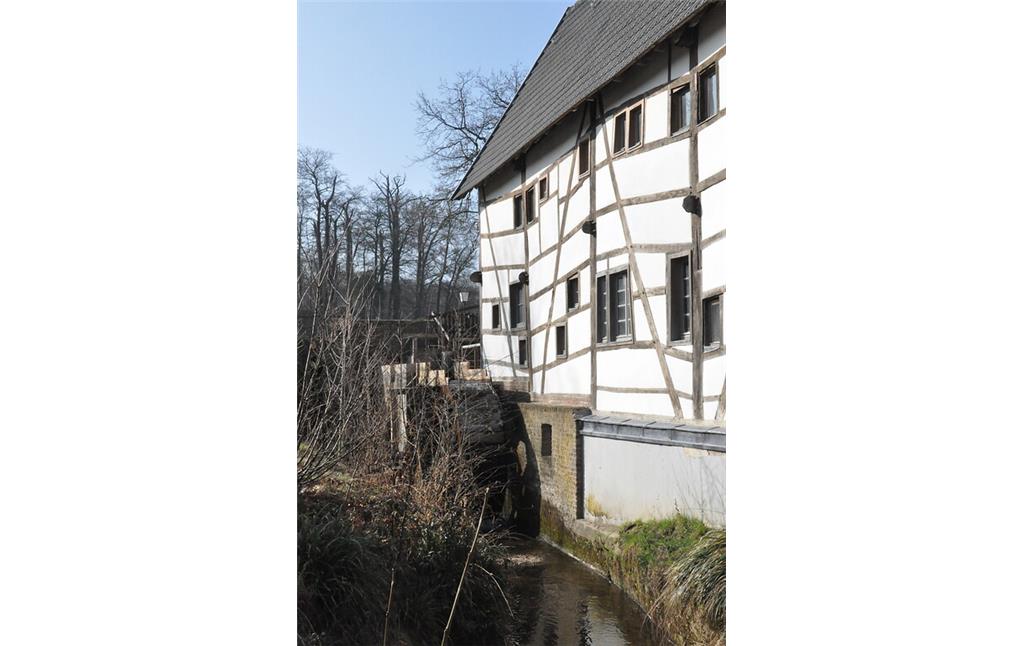 Das oberschlächtige Wasserrad der Tüschenbroicher Mühle ist an der Ostseite des Mühlengebäudes angebracht (2021)