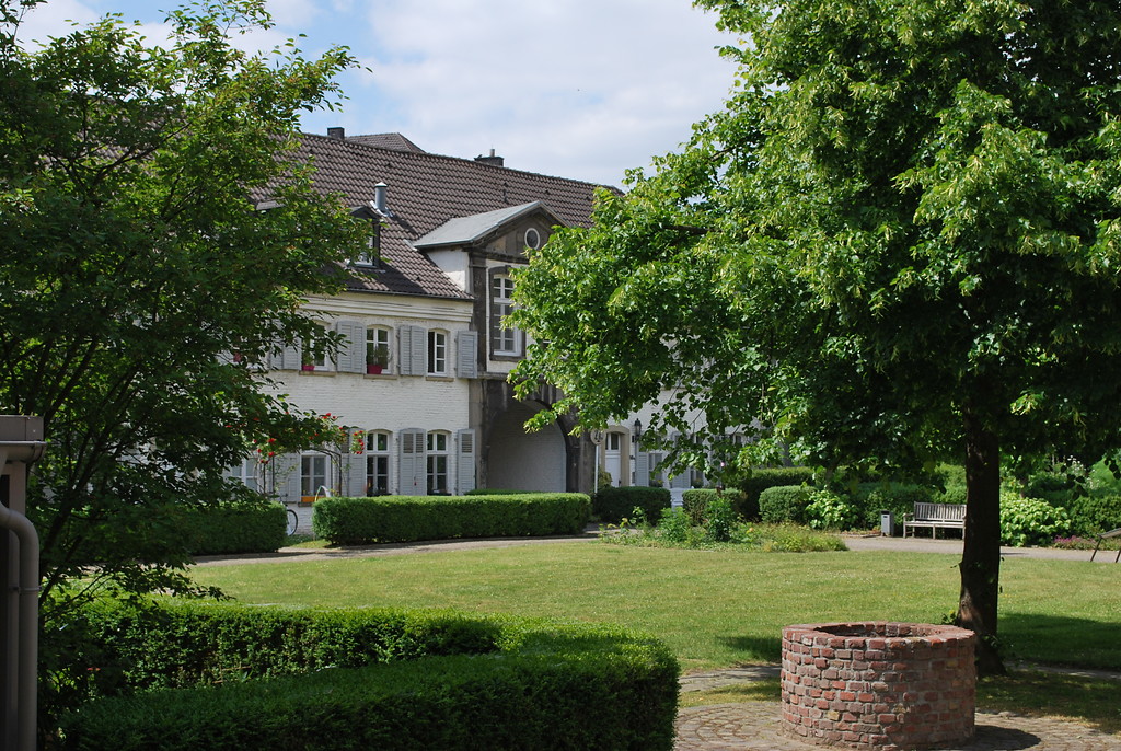 Der Innenhof des Klosters Saarn ist weitläufug und gärtnerisch gestaltet. Er wird durch die barocken Klostergebäude nach außen abgeschlossen. Der Zugang zum Klosterhof erfolgt durch einen Torbogen (2015).
