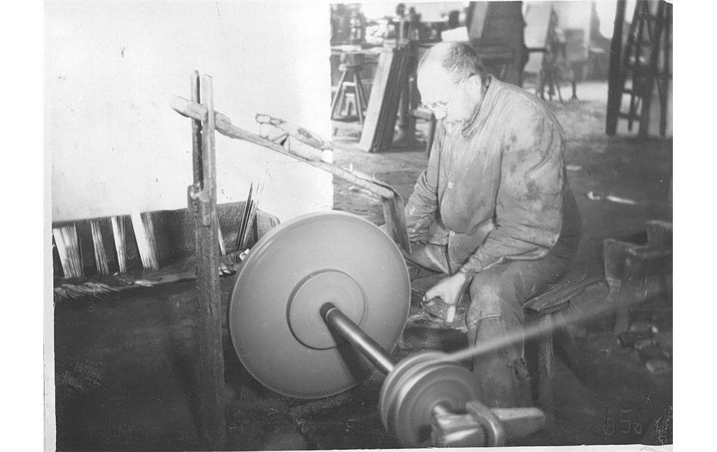Arbeiter an einem kleinen Schleifstein  in der damaligen Messerfabrik Stöcker in Friedenthal (um 1930)