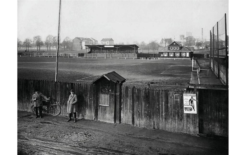 Historische Aufnahme des Sportplatzes in der Bonner Richard-Wagner-Straße aus dem Jahr 1927. Auf einem Plakat am den Platz umgebenden Holzzaun wird ein Spiel gegen "Borussia M.-Gladbach" angekündigt.