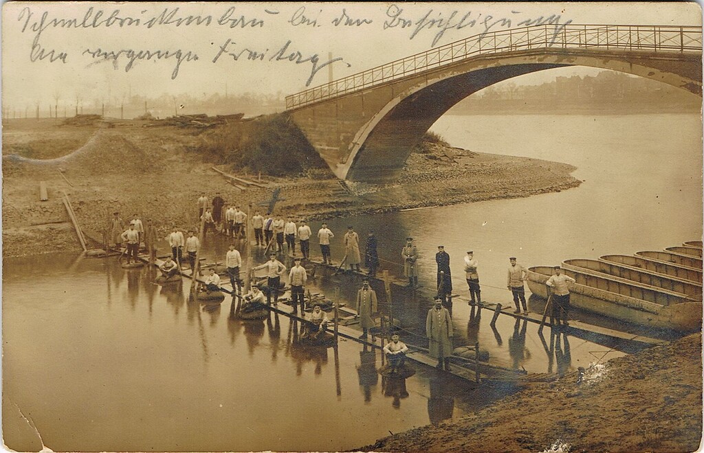 Historische Postkarte (gelaufen 1914): Pioniere stehen auf Stegen unter der Brücke zum Pionierhafen der Kaserne in Köln-Riehl.