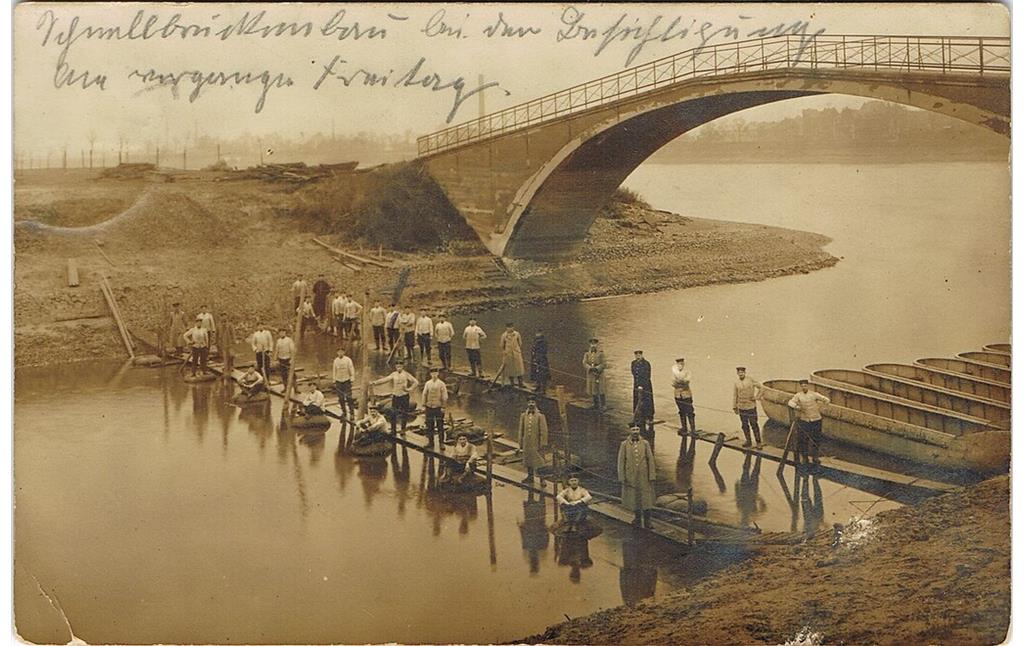 Historische Postkarte (gelaufen 1914): Pioniere stehen auf Stegen unter der Brücke zum Pionierhafen der Kaserne in Köln-Riehl.
