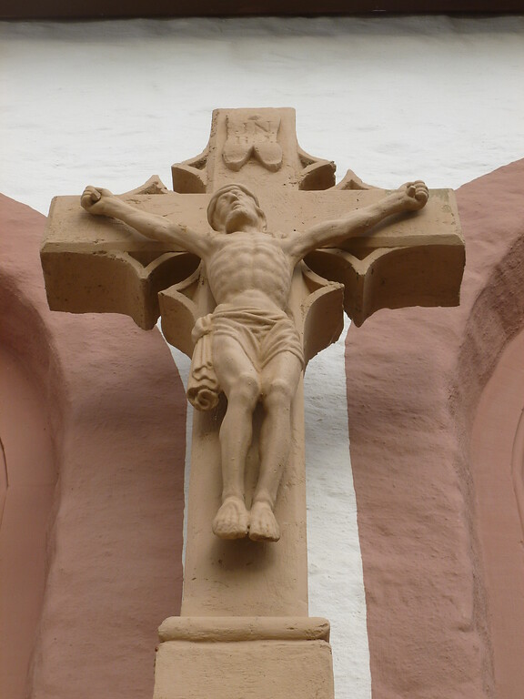 Der Korpus des Sandsteinkreuzes an der Pfarrkirche St. Andreas in Glehn ist kunstvoll ebenfalls aus Sandstein gearbeitet. (2014)