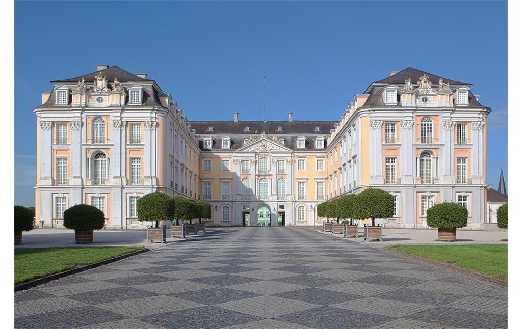 Frontansicht des Schlosses Augustusburg mit Außenanlage in Brühl mit gepflasterter Promenade (2015)