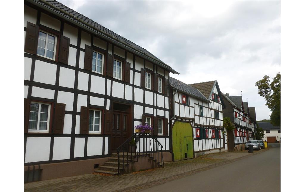Diese Häuserzeile in Hostel gegenüber des Dorfangers besteht aus Fachwerkgebäuden mit überwiegend rechtwinkligen Gefachen. (2014)