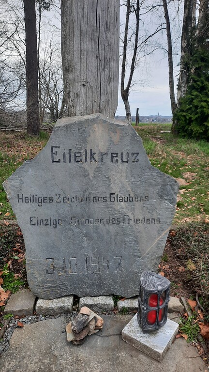 Am Fuß des "Eifelkreuzes" befindet sich diese Steintafel. Die Inschrift lautet: "Eifelkreuz Heiliges Zeichen des Glaubens. Einziger Bringer des Friedens. 3.10.1947" (2023)