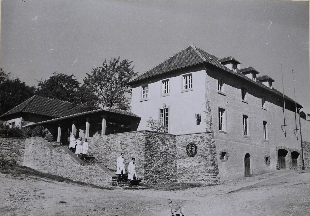 Bild 34: An der unteren Natursteinmauer der "Hermann Göring Meisterschule" in Kronenburg war das schmiedeeiserne Emblem seit der Eröffnung 1938 angebracht.