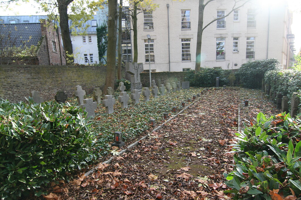 Friedhofsbereich mit Priestergräbern und historischen Grabsteinen an der Kirche Sankt Audomar (2021)