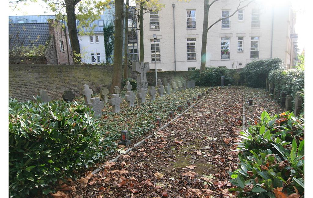 Friedhofsbereich mit Priestergräbern und historischen Grabsteinen an der Kirche Sankt Audomar (2021)