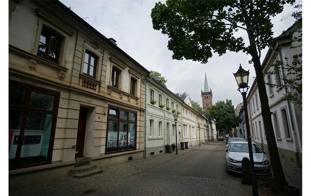 Die niedrigen, historischen Steinhäuser an der Fabrikstraße stehen traufseitig zur Straße. Am Ende der Straße steht als Blickpunkt ein Kirchturm (2020).