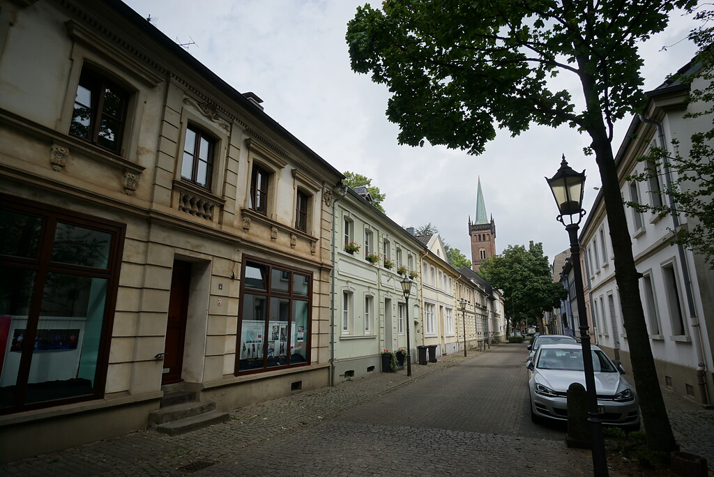 Die niedrigen, historischen Steinhäuser an der Fabrikstraße stehen traufseitig zur Straße. Am Ende der Straße steht als Blickpunkt ein Kirchturm (2020).