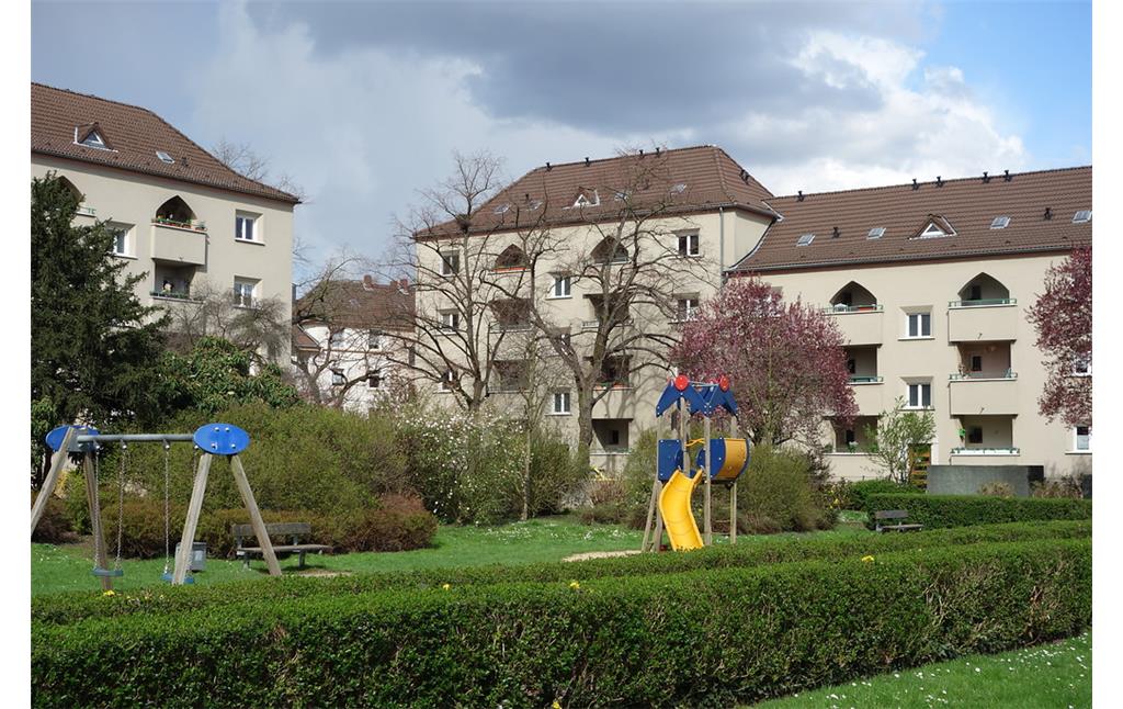 Köln-Mauenheim: Die Eckhäuser am Ende der langen Mehrfamilienhausreihen springen baulich in der Front und Höhe etwas vor und betonen damit die Eingangsbereiche der Siedlung (2016).