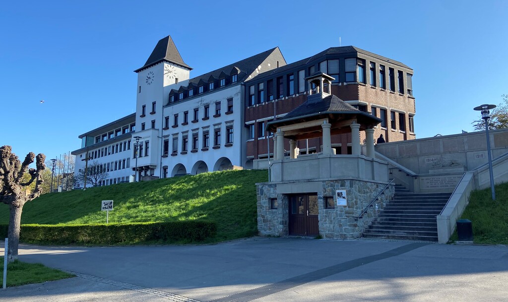 Das Porzer Rathaus vom Rheinufer aus gesehen mit dem Kernbau von 1910 in der Mitte, dem ersten Erweiterungsbau von 1956 links und dem zweiten Erweiterungsbau von 1983 rechts (2023).
