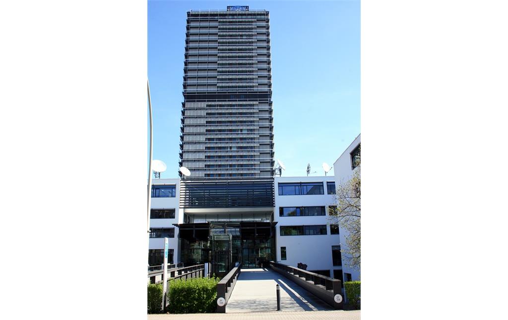 Der Eingangsbereich zum Gebäudekomplex der Deutschen Welle von der Kurt-Schumacher-Straße in Bonn (2015); im Hintergrund das frühere Abgeordnetenhochhaus "Langer Eugen".
