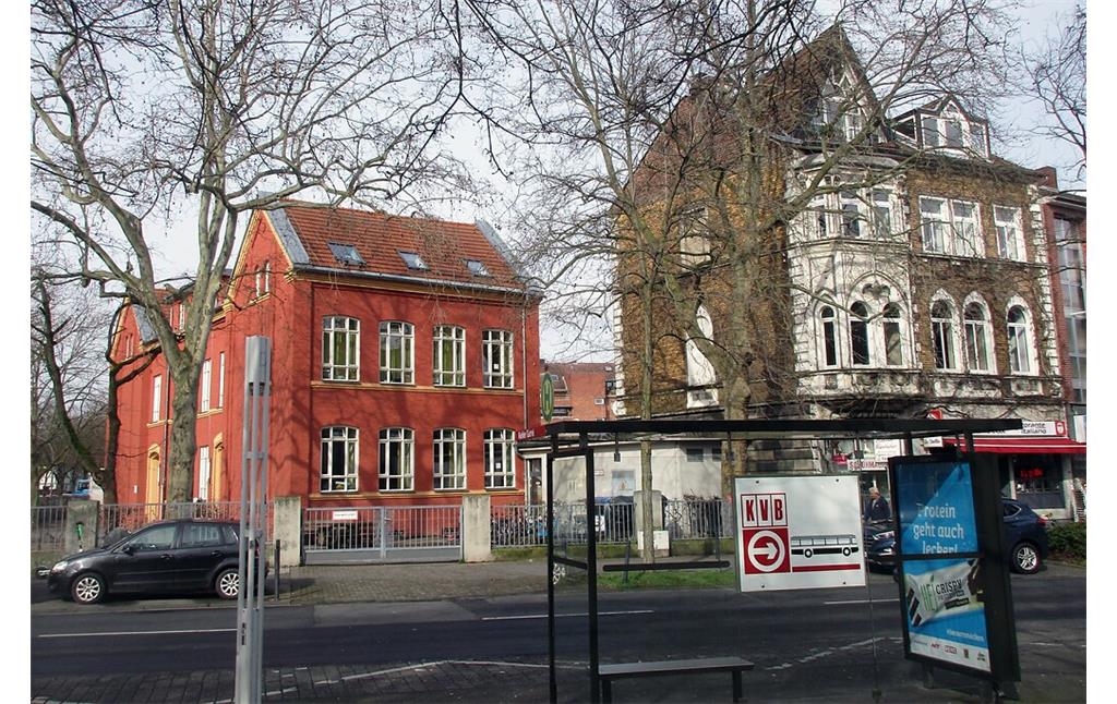 Blick vom früheren namenlosen Dorfplatz von Köln-Riehl, dem so genannten "Riehler Plätzchen" auf die alte Schule links im Bild (2020).