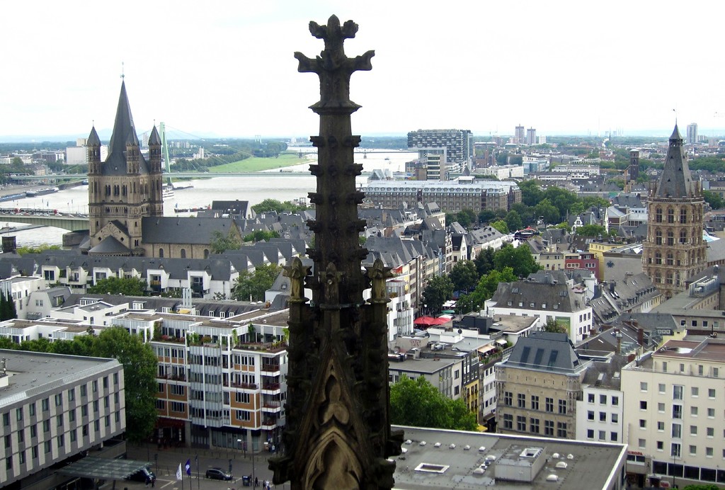 Die ehemalige Benediktinerabtei Groß-Sankt Martin (links) und der Turm des Kölner Rathauses (rechts), dazwischen der Alte Markt, Ansicht vom Dach des Kölner Doms aus (2014).