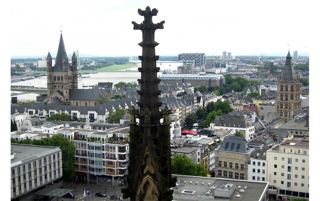 Die ehemalige Benediktinerabtei Groß-Sankt Martin (links) und der Turm des Kölner Rathauses (rechts), dazwischen der Alte Markt, Ansicht vom Dach des Kölner Doms aus (2014).