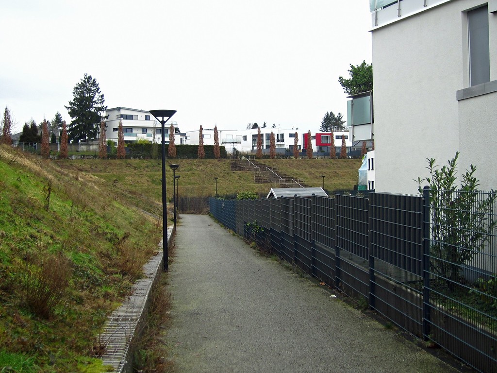 Schmaler Pfad zwischen der erhaltenen Südterrasse und der neuen Wohnanlage mit Blick auf die Terrasse der Haupttribüne des ehemaligen Bökelbergstadions (2015).