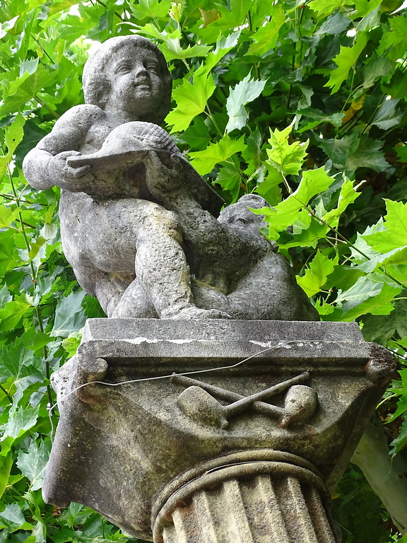 Zwei Figuren auf einer Säule am Hutmacherbrunnen in Kusel (2018).