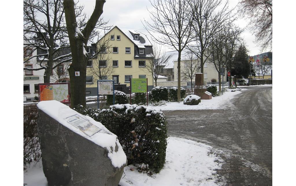 Marktplatz von Kelberg mit Hinweisschildern und der Station 1 der Geschichtsstraße (Abschnitt 2) im Jahr 2009