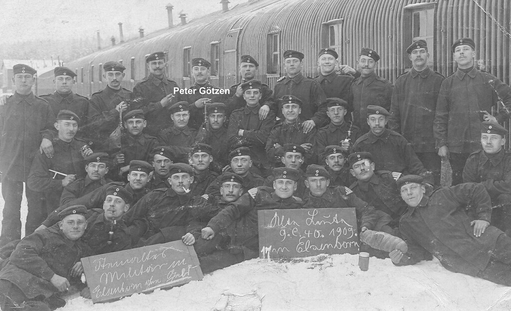 Historische Aufnahme von 1909 mit 35 Soldaten des preußischen Militärs, die vor einer Kasernenbaracke posieren (als Feldpostkarte vom Truppenübungsplatz Elsenborn gelaufen).