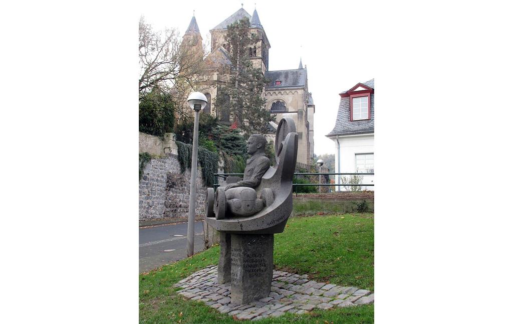 Das Denkmal für den Rennfahrer Rudolf Caracciola (1901-1959), dahinter die katholische Pfarrkirche St. Peter und Paul in Remagen (2020).
