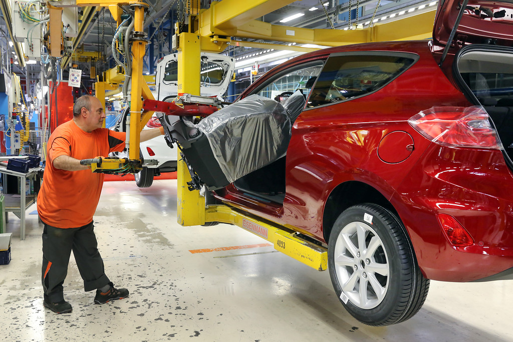 Fließbandproduktion im Ford-Autowerk in Köln-Niehl (2017), der Einbau des Fahrersitzes in einen Ford Fiesta wird durch eine hydraulische Hubvorrichtung unterstützt.