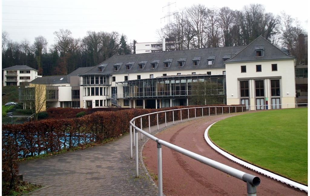 Ansicht des 1950 erbauten Hauptgebäudes der Sportschule Hennef mit dem davor liegenden Empfangsgebäude von 2006 (Ansicht vom Sportplatz aus 2014)