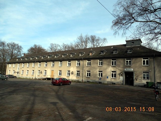 Ein Gebäude (ehemaliger Kasernenbau) des ehemaligen Militärflughafens Ostheim in Merheim mit Beobachtungsturm (2015)