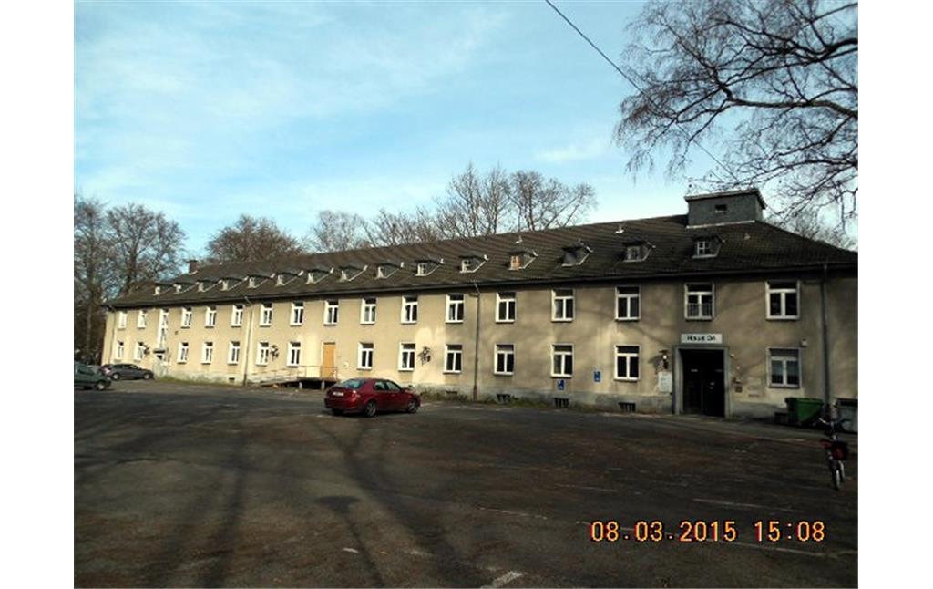 Ein Gebäude (ehemaliger Kasernenbau) des ehemaligen Militärflughafens Ostheim in Merheim mit Beobachtungsturm (2015)