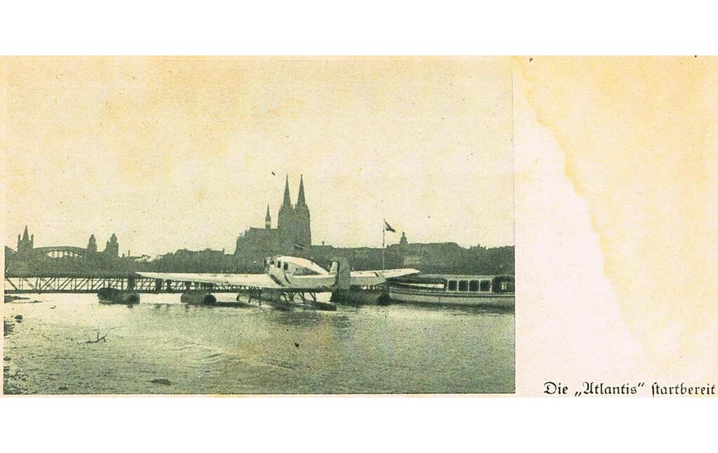 Historische Aufnahme von Hans Bertrams Start zu dem legendärem "Flug in die Hölle" 1932/33 aus dem gleichnamigen Buch. Das Bild "Die 'Atlantis' starbereit" zeigt die Junkers W 33 an Ihrem Startplatz am Rheinpark, im Hintergrund der Kölner Dom.