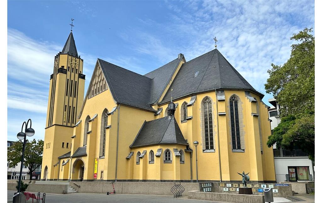 Die katholische Pfarrkirche St. Josef in Köln Porz, Blick von Westen aus auf den Chor und den Seiteneingang (2023).
