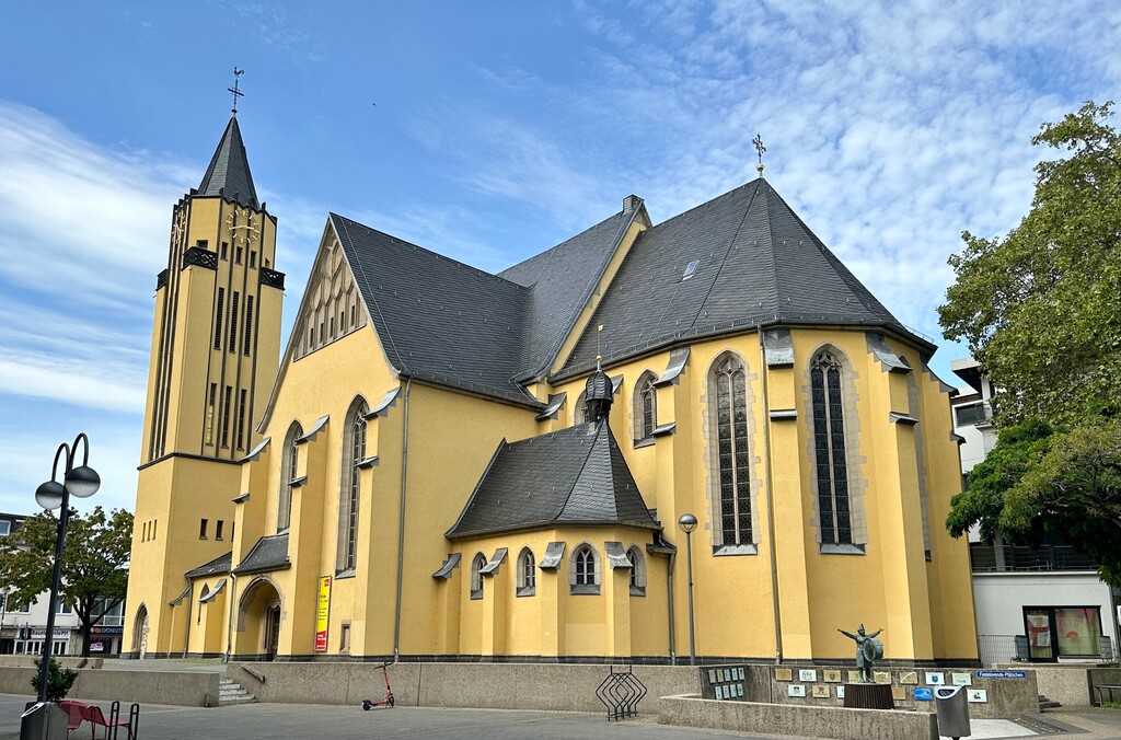 Die katholische Pfarrkirche St. Josef in Köln Porz, Blick von Westen aus auf den Chor und den Seiteneingang (2023).