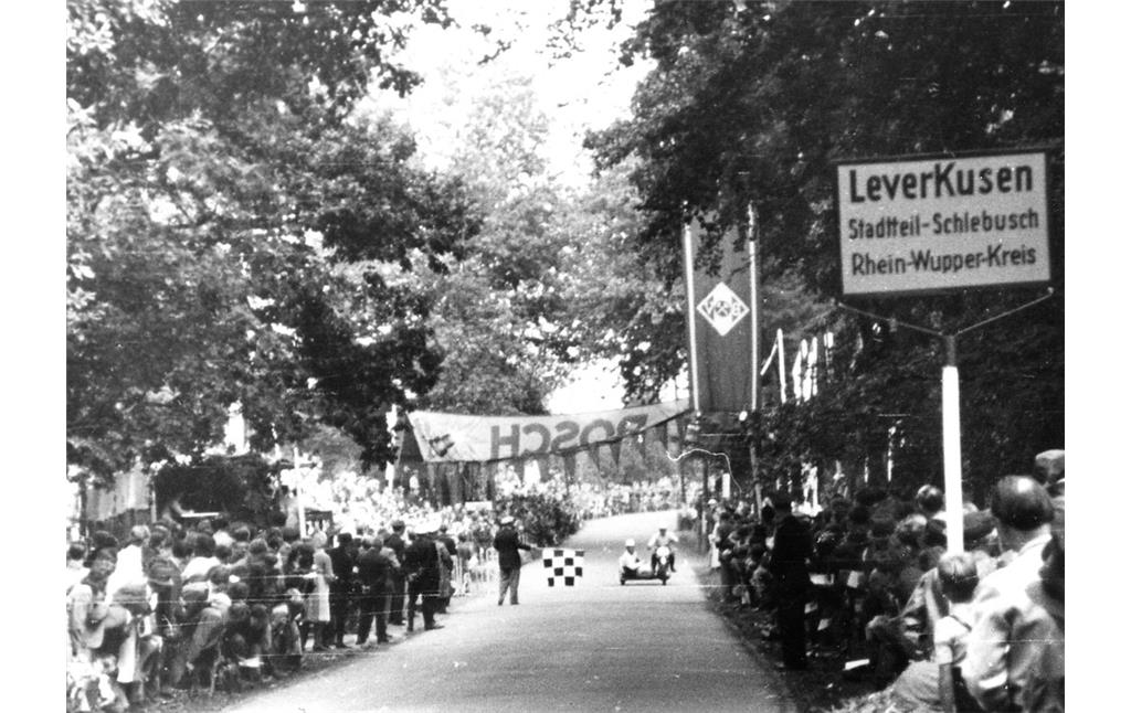 Der Zieleinlauf in der damaligen Zuccalmaglio-Straße (heute Opladener Straße) als Teil der Strecke des Motorsport-Rennens "Um das Bayerkreuz" am 12. September 1948 bei Leverkusen.