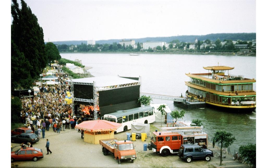 Ein Festival an der Beueler Seite der Bonner Kennedybrücke (1991), rechts im Bild das Restaurantschiff "Ocean City", das von 1929 bis 1987 als Fährschiff "Königswinter II" in Betrieb war.