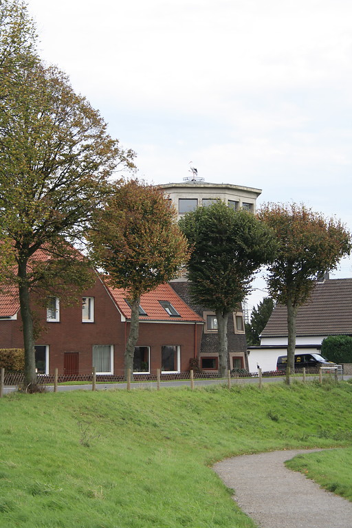 Das Haus Storchennest (ehemalige Turmwindmühle) inmitten einer Häuserreihe an der Dammstraße in Götterswickerhamm. Auf dem Aussichtsturm ist ein Storch aus gehämmertem Stahlblech angebracht (2014).