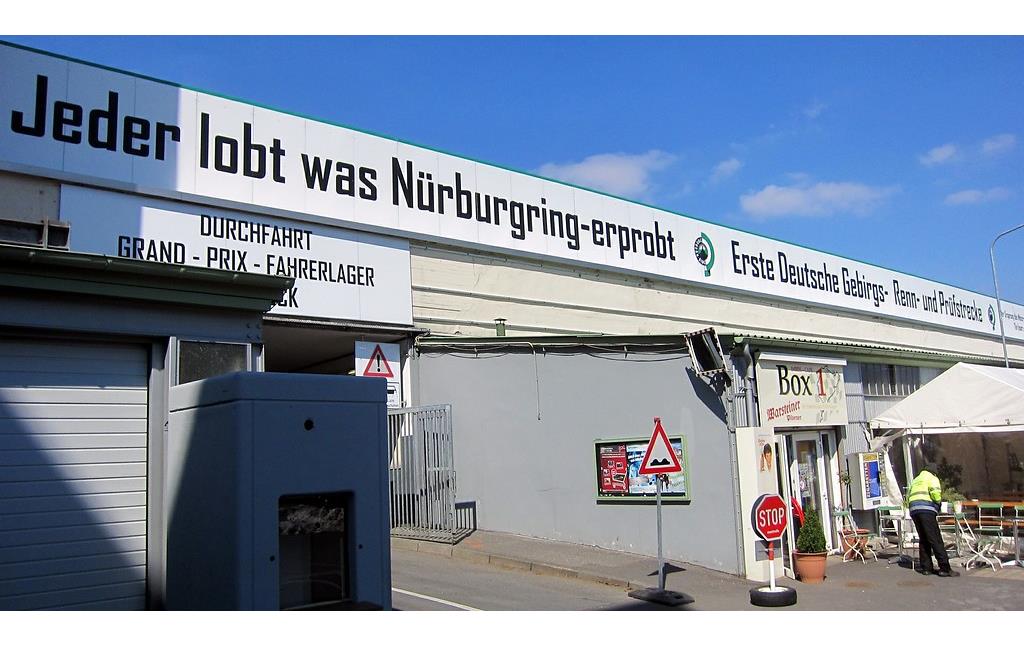 Teil des alten Fahrerlagers am Nürburgring und die Einfahrt zum neuen Fahrerlager, darüber der Werbespruch von 1935 "Jeder lobt was Nürburgring erprobt" (2013)