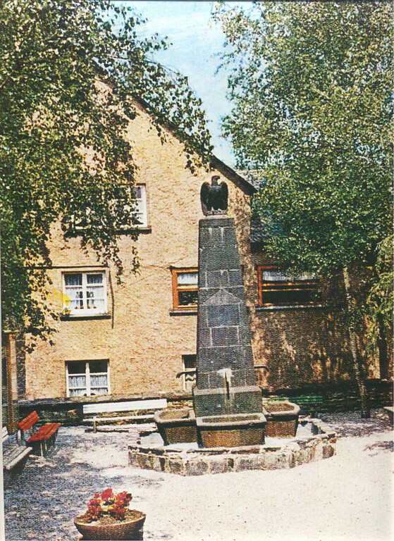 Der Adler-Brunnen in Briedel stammt aus dem 19. Jahrhundert und wurde im Jahr 1970 abgebaut (Aufnahme aus den 1960er-Jahren).