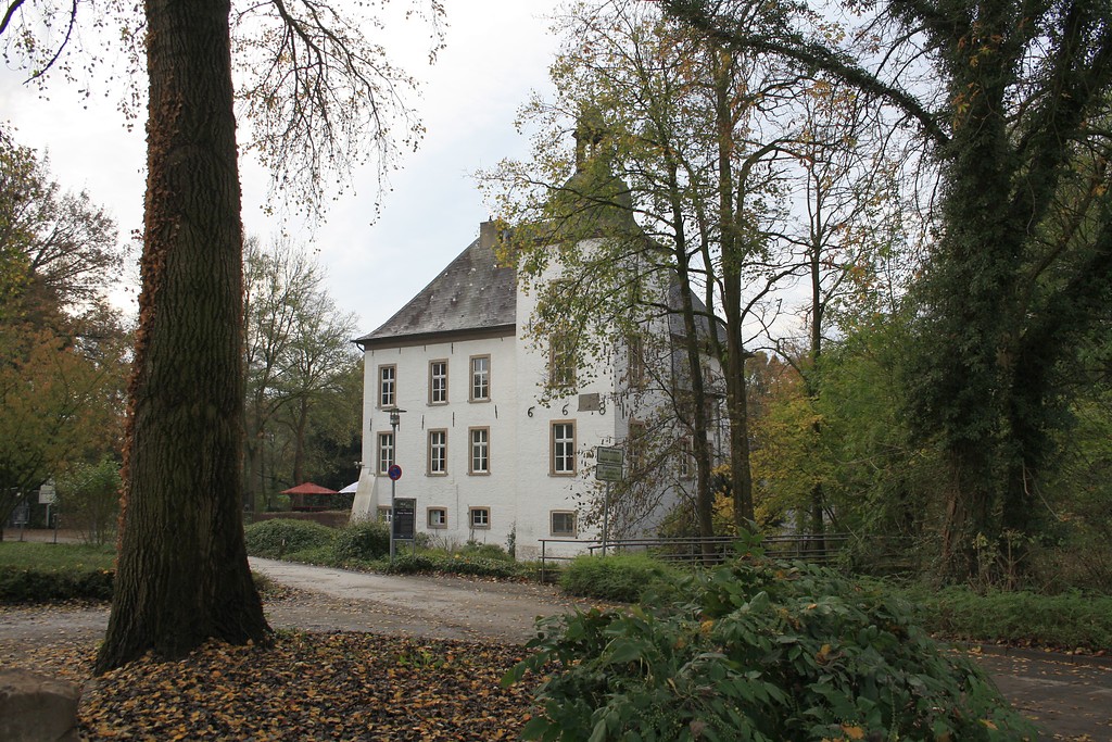 Zufahrt mit angrenzendem Parkplatz zur Wasserburg Haus Voerde an der Allee in Voerde (2014).