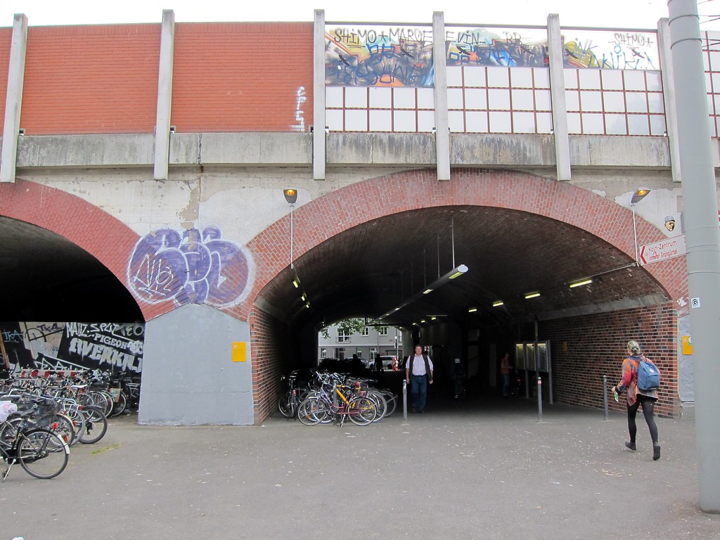 Östlicher Zugang zum Bahnhof Köln-Ehrenfeld an der Ecke Ehrenfeldgürtel/Hüttenstraße (2015). Für den Zugang wurde eines der Gewölbe der Viaduktbrücke, auf der die Bahnstrecke hier verläuft, saniert und geöffnet.