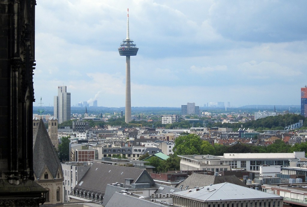 Blick vom Dach des Doms über die Stadt Köln in Richtung Westen, mittig ist der Fernseh- und Radio-Sendeturm "Colonius" zu sehen und im Hintergrund die rund 30 Kilometer entfernten Braunkohlekraftwerke bei Grevenbroich (2014)