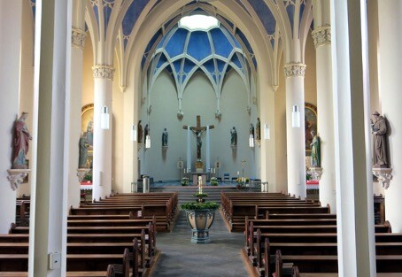 Blick auf das Taufbecken und den dahinter liegenden Chor der Pfarrkirche Sankt Johannes der Täufer in Treis (2022)