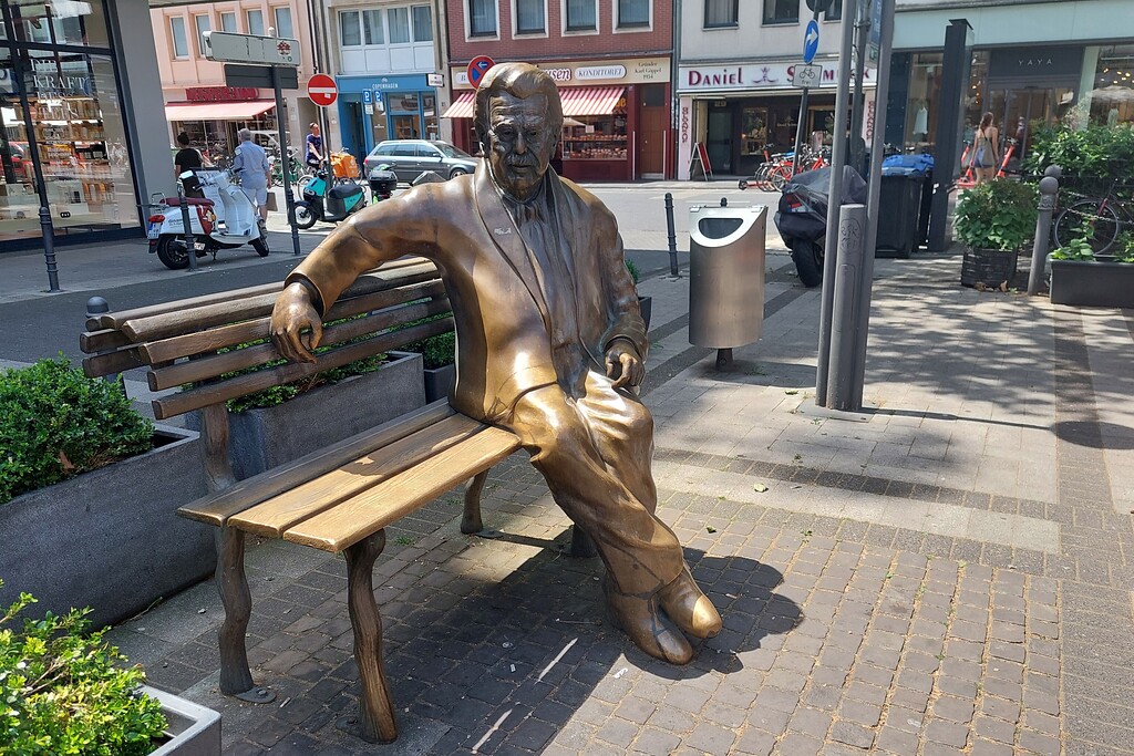 Bronzedenkmal des Kölner Volksschauspielers Willy Millowitsch (1909-1999) auf dem nach ihm benannten Willy-Millowitsch-Platz in Köln-Altstadt-Nord (2021).