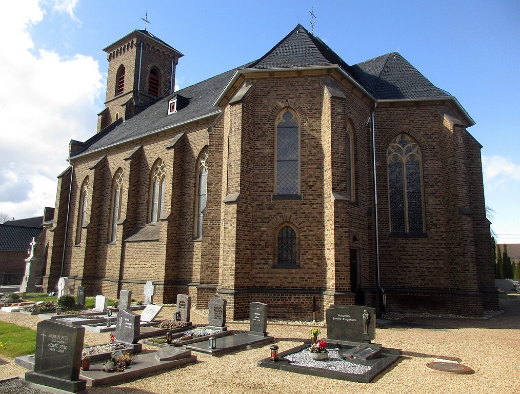 Blick auf die Südseite der katholischen Pfarrkirche Sankt Johann Baptist mit dem umgebenden Friedhof in Vettweiß-Sievernich (2021).