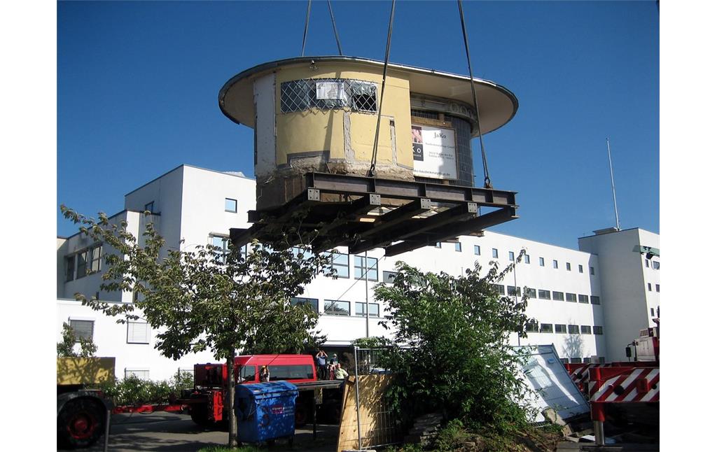 Ein Kran hebt das denkmalgeschützte "Bundesbüdchen"  einen Kiosk im Bonner Regierungsviertel  an, um diesen zu seinem Zwischenlager, einem Bauhof in Hersel, transportieren zu können (2006).