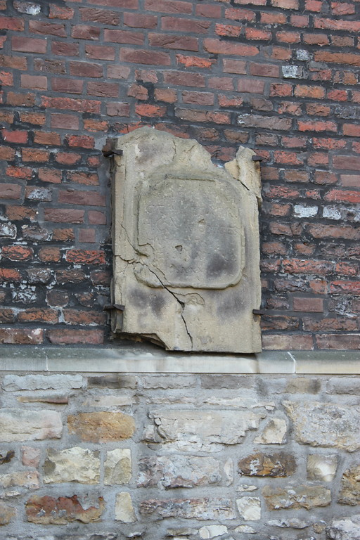 Stark zerschlissene Grabtafel, deren Inschrift nicht mehr zu erkennen ist (2014). Die Tafel ist an der Außenfassade der Kirche am alten Friedhof "De Widow" in Gahlen befestigt.