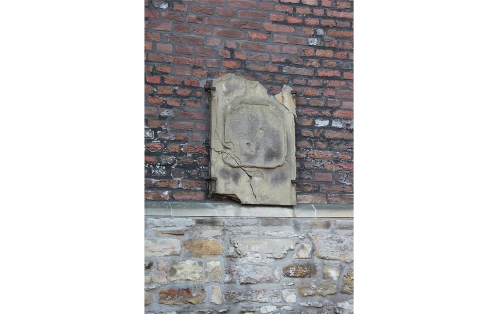 Stark zerschlissene Grabtafel, deren Inschrift nicht mehr zu erkennen ist (2014). Die Tafel ist an der Außenfassade der Kirche am alten Friedhof "De Widow" in Gahlen befestigt.