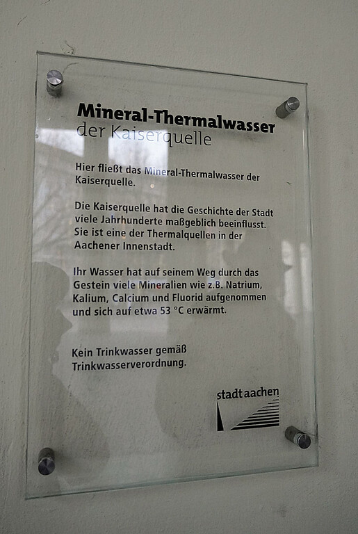 Informationstafel zu der Mineral-Thermalwasserquelle des Elisenbrunnens in Aachen-Mitte (2021).