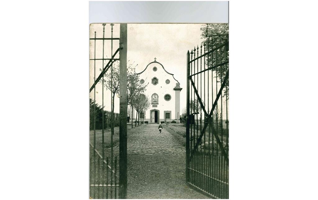 Historische Fotografie der Marienkapelle in Kirrweiler durch das offene Tor (1950er Jahre)